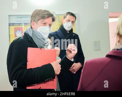 Berlin, Deutschland. 14th Januar 2022. Daniel Wesener (l., Bündnis 90/die Grünen), Berliner Finanzsenator, spricht mit Martin Hikel (SPD), Bezirksbürgermeister von Neukölln, und Franziska Giffey (SPD, r), Regierende Bürgermeisterin von Berlin, bei einem Besuch im Gesundheitsamt in Neukölln. In Neukölln ist die Inzidenz im Vergleich zum Rest Deutschlands sehr hoch. Quelle: Annette Riedl/dpa/Alamy Live News Stockfoto