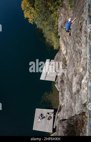 Kletterer auf der Jungfernsprung Kletterwand am Millstätter See wird sie von Flößen auf dem See, Döbriach, Kärnten, Österreich, Europa weggeklettert Stockfoto