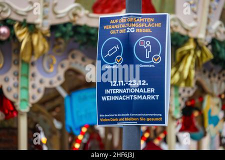 Essen, Nordrhein-Westfalen, Deutschland - Weihnachtsmarkt in Essen in Zeiten der Corona-Pandemie unter 2G Bedingungen. Hinweisschild für die Corona-Schutzverordnung. Die Besucher müssen sich erholt haben oder geimpft sein. In der Essener Fußgängerzone gibt es keine Pflicht, eine Maske zu tragen, sondern eine Empfehlung, eine Maske zu tragen. Stockfoto