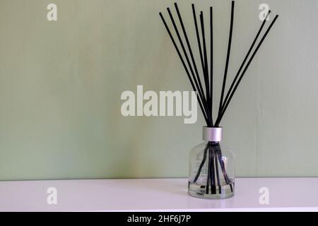Aroma-Schilf-Diffusor, Raumduft-Flasche mit Rattan-Sticks und Duft von  Frische auf dunklem Hintergrund mit grünen Palmblättern Stockfotografie -  Alamy