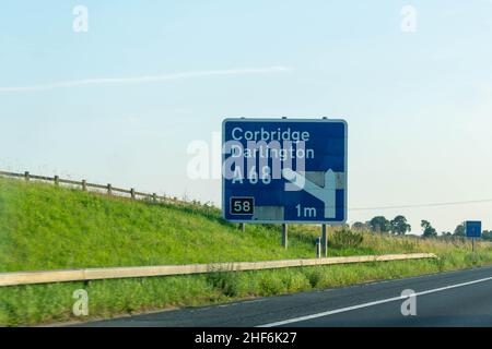 Blaues Straßenschild auf einer britischen Autobahn für die Ausfahrt 58 der verkehrsreichen Autobahn A1 nach Corbridge und Darlington. Speicherplatz kopieren. Stockfoto