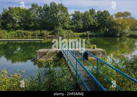 Waltrop, Nordrhein-Westfalen, Deutschland, Schiffshebewerk Waltrop. Hier ist ein Steg auf dem oberen Wasser des alten, ausgedient Schachtschlosses. Die vier Abstiegsanlagen am Abzweig des Rhein-Herne-Kanals vom Dortmund-Ems-Kanal sind als Waltrop-Schleusenpark bekannt. Das einzige Hubsystem, das in Betrieb ist, ist das Neue Schloss, das 1989 zwischen dem alten Schachtschloss und dem neuen Aufzug gebaut wurde. Stockfoto