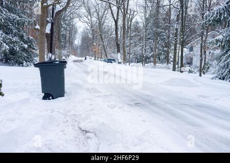 Die Straße ist nach dem Schneesturm in der Vorstadt mit Schnee bedeckt Stockfoto