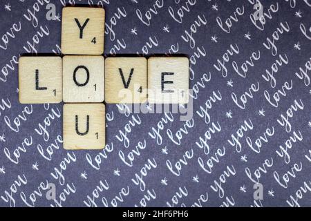 Liebe und Romantik Konzept. Love You schrieb auf Scrabble spielen Würfel auf einem lila Ich liebe dich Hintergrund. Valentinstag, romantisches Konzept, Begleiter Stockfoto