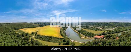 Schöner Blick über die geschwungene Isar in südbayern mit einem breiten gelben Feld und vielen Bäumen an einem schönen Sommertag Stockfoto