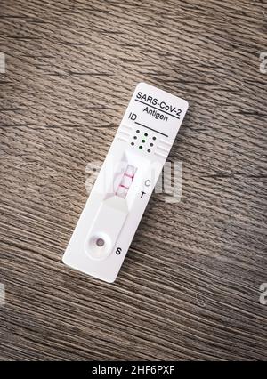 Nahaufnahme eines Corona-Schnelltests zu Hause, bei dem die Ergebnisse nach 15 Minuten mit dem positiven, zweistreifigen Testergebnis erzielt werden, das besorgt ist, vom Covid-19-Virus infiziert zu werden Stockfoto