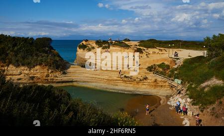 Griechenland, griechische Inseln, Ionische Inseln, Korfu, Nordküste, Bizarre Felsformationen an der Küste, Canal d'amour, blauer Himmel, weiße Wolken, türkisfarbenes Meer, Blau und grün, Bucht mit Menschen, felsige Küste Stockfoto