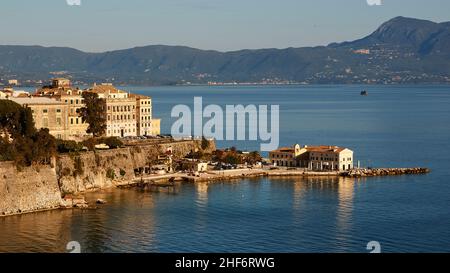 Griechenland, Griechische Inseln, Ionische Inseln, Korfu, Korfu-Stadt, Altstadt, alte Festung, Blick von der Festung auf Häuserzeile direkt über das Meer und den Faliraki, einem kleinen Strand mit Cafés und Restaurants Stockfoto