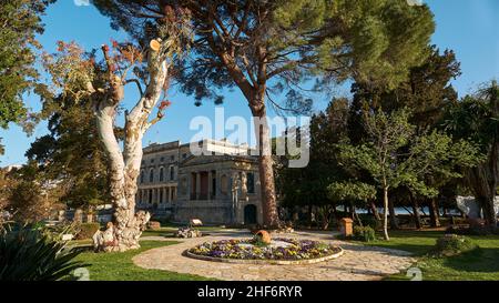 Griechenland, Griechische Inseln, Ionische Inseln, Korfu, Korfu-Stadt, Altstadt, Park von Platia Leonida Vlachou mit Bäumen und Blick auf das Museum für asiatische Kunst Stockfoto