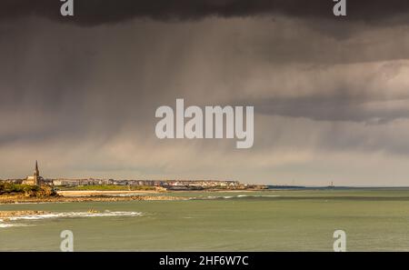 Der Blick auf Tynemouth, Cullercoats & Whitley Bay inklusive St Mary's Lighthouse von Tynemouth's North Pier an einem regnerischen Tag Stockfoto