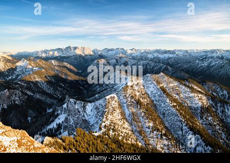 Schneebedeckte alpine Berglandschaft bei Sonnenuntergang im frühen Winter. Blick von Säuling über die Ammergauer Alpen auf den Wetterstein mit der Zugspitze und der Mieminger-Kette. Tirol, Österreich, Europa Stockfoto