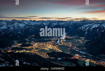 Reutte, beleuchtet in der Dämmerung an einem kalten Herbstabend, vom Säuling aus gesehen. Umrahmt von den schneebedeckten Lechtal- und Allgäuer Alpen. Tirol, Österreich, Europa Stockfoto