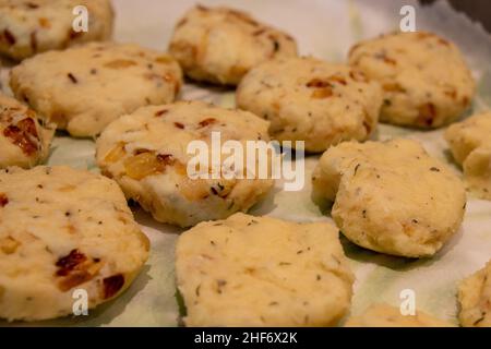 Zum Braten wird ein Tablett mit ungekochten runden, salzigen Kabeljau-Fischkuchen vorbereitet. Die Mischung aus Bohnenkraut, Kartoffeln, Salz-Kabeljau und Butter wird zu kleinen Patties geformt. Stockfoto