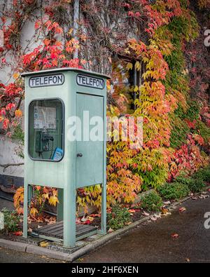 HARLÖSA, SCHWEDEN - 17. OKTOBER 2021: Eine Retro-Telefonbox im nostalgischen Museum im Stadtzentrum. Stockfoto