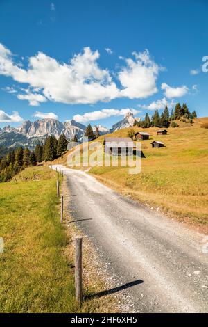 Italien, Südtirol, Provinz Bozen, Corvara in Badia, Alpenlandschaft mit Holzhütten auf den Inkisa-Wiesen, auf den Gipfeln der Puez-Gruppe, Dolomiten Stockfoto