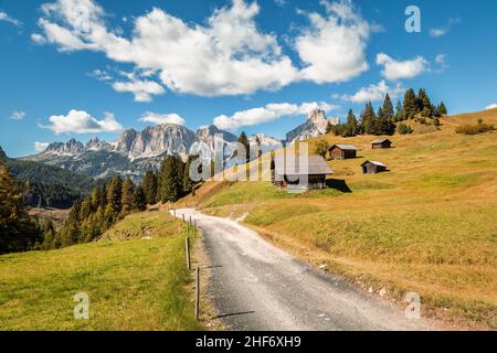 Italien, Südtirol, Provinz Bozen, Corvara in Badia, Alpenlandschaft mit Holzhütten auf den Inkisa-Wiesen, auf den Gipfeln der Puez-Gruppe, Dolomiten Stockfoto