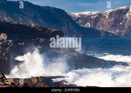 Eine wütende, türkisgrüne Farbe, massive Wellen, die sich an einem Strand entlang Rollen. Der weiße Nebel und der Schaum der Welle sind schaumig und flauschig. Stockfoto