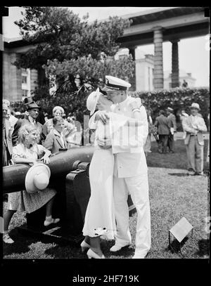 Nach den Abschlussfeiern an der United States Naval Academy küsst ein neuer Offizier sein Mädchen. Im Hintergrund reagieren ein junges Mädchen und ein Junge auf den Kuss unterschiedlich, Annapolis, MD, 1935. Stockfoto