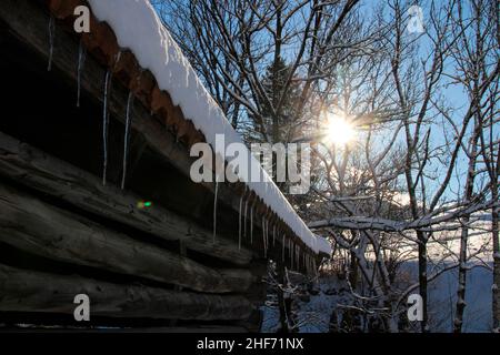 Winterspaziergang bei Mittenwald, Heuscheune, Eiszapfen, Laubbäume im Hintergrund, stimmungsvoll, Europa, Deutschland, Bayern, Oberbayern, Werdenfels, Winter, Karwendelgebirge, Stockfoto