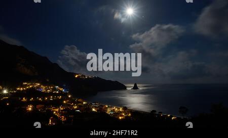 Griechenland, griechische Inseln, Ionische Inseln, Korfu, Westküste, Agios Gordios, Nachtaufnahme, Vollmond, Felsen, Ortholithos, bucht von Agios Gordios, beleuchtete Häuser, Mondlicht am Meer, Mond als radialer Punkt, nächtlicher blauer Himmel, Wolken Stockfoto