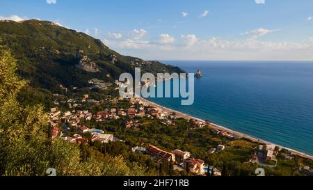 Griechenland, griechische Inseln, Ionische Inseln, Korfu, Westküste, Agios Gordios, Blick von oben auf die Bucht, Häuser, Hotels, im Hintergrund auf dem linken grünen Küstenhügel, daneben der vorgelagerte Felsen Ortholithos Stockfoto