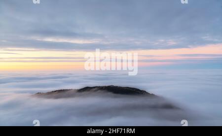 Nach Sonnenuntergang erhebt sich der einsame Gipfel des Breitenberg bei Pfronten aus dem Wolkenmeer. Allgäuer Alpen, Bayern, Deutschland, Europa Stockfoto