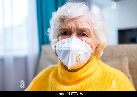 Doktor, der einer älteren Frau in ihrem Haus im Wohnzimmer eine Injektion gab Stockfoto