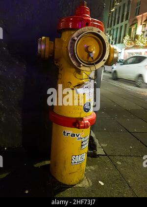 Roter und gelber Hydrant im Stadtzentrum von Reykjavik, Island. Diese niedlichen und üblichen Feuerhydranten sind im Stadtzentrum verteilt. Touristen l Stockfoto