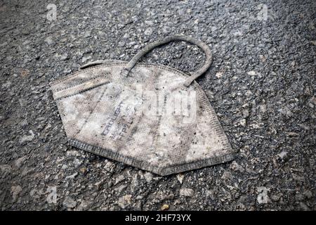 München, Deutschland. 11th Januar 2022. Themenbild, symbolisches Foto: Ende der Coronapandemie. Schmutzige FFP2 Maske liegt auf dem Boden. Eine weggeworfene Gesichtsmaske liegt auf Asphalt, Straße, Bürgersteig, Untergrund, Schmutz, earth.ground. Kredit: dpa/Alamy Live Nachrichten Stockfoto