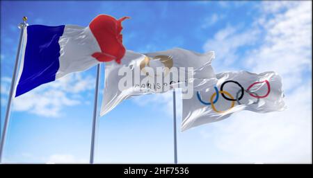 Paris, Frankreich, Januar 2022: Die olympische Flagge von Paris 24 winkt im Wind zwischen der französischen und der olympischen Flagge. Die Olympischen Sommerspiele 2024 in Paris sind sc Stockfoto