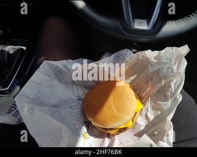 Newcastle upon Tyne, England - 24th. Mai 2019: Frauen essen ein schnelles Mittagessen mit Burger in ihrem Auto. Geschäftiges Geschäftsleben, das bis zum Mittagessen fährt o Stockfoto