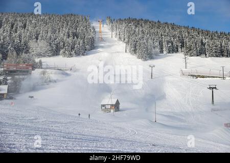 12. Januar 2022, Sachsen, Oberwiesenthal: Aus zahlreichen Lanzen ist der Hang am Fichtelberg mit Schnee bedeckt. Am Samstag, 15.01.2022, wird die diesjährige Skisaison am Fichtelberg offiziell eröffnet. Aufgrund von Corona ist das Skigebiet nur für geimpfte und genesene Personen zugänglich (2G), und beim Anstehen am Lift und im Lift selbst muss eine Maske getragen werden. Der Status von 2G wird vor dem Kauf des Skipasses sowie im Skigebiet überprüft. Zu diesem Zweck werden auf dem Parkplatz der Seilbahn Fichtelberg eine Kontrollstelle und eine zentrale Verkaufsstelle für Lifttickets eingerichtet Stockfoto