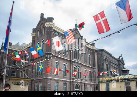 Amsterdam, Holland, Niederlande - 6th. Mai 2019: Zahlreiche Nationalitätenfahnen fliegen an einem Sommertag im Wind auf dem Amsterdamer Kanal