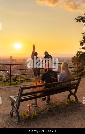 Touristen genießen den Sonnenuntergang auf dem Schlossberg, Freiburg im Breisgau, Südschwarzwald, Baden-Württemberg, Deutschland Stockfoto