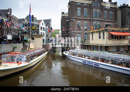 Amsterdam, Holland, Niederlande - 6th. Mai 2019: Zahlreiche Nationalitätenfahnen fliegen an einem Sommertag im Wind auf dem Amsterdamer Kanal