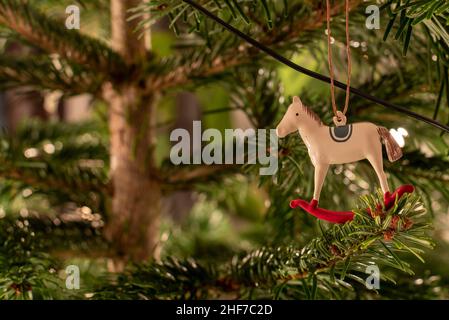 Ein Metallpferd hängt an einem Weihnachtsbaum. Stockfoto