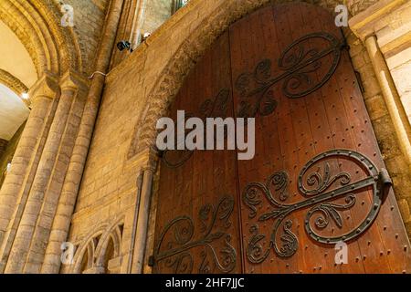 In der Kathedrale von Durham, England, Großbritannien. Innenraum der Kathedrale Kirche Christi, der seligen Jungfrau Maria und St. Cuthbert von Durham. Die große Holztür Stockfoto