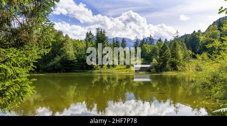 Schmölzer See bei Garmisch-Partenkirchen mit Blick auf eine Bootshütte bei schönem Wetter, Bayern, Deutschland Stockfoto