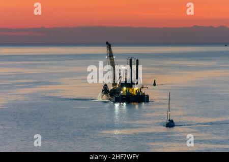 Vordingborg, Meerenge Storstroemmen, Sonnenuntergang, Unterwasser-Baggerarbeiten für den Bau einer neuen Storstroem-Brücke in Masnedoe, Seeland, Sjaelland, Dänemark Stockfoto