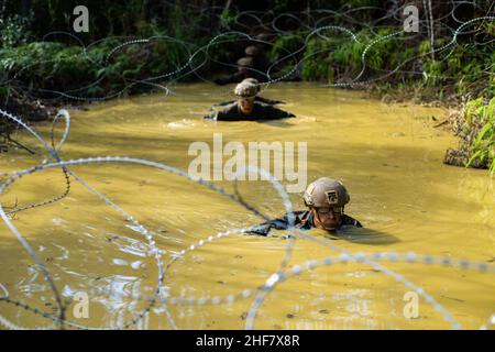 Okinawa, Japan. 7th Januar 2022. Marines führen den Ausdauerkurs während des Mannschaftswettbewerbs der Marine Division 3rd in Camp Gonsalves, Okinawa, Japan, am 7. Januar 2022 durch. Der einwöchige Wettbewerb testet die Überlebensfähigkeiten des Dschungels, grundlegende Infanterietaktiken und Exzellenz im Waffenhandling.Quelle: U.S. Navy/ZUMA Press Wire Service/ZUMAPRESS.com/Alamy Live News Stockfoto