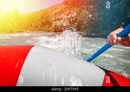 Rafting auf einem Bergfluss. Nahaufnahme der Seite des Floßbootes mit Ruder in der Hand. Stockfoto