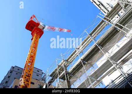 Blauer Himmel und farbenfrohe Baukräne auf einer Baustelle Stockfoto