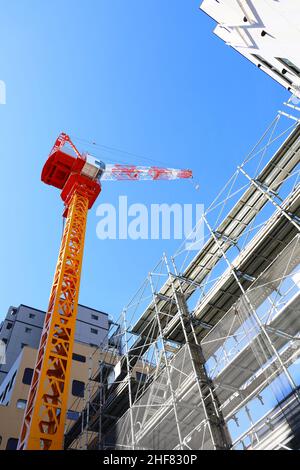 Blauer Himmel und farbenfrohe Baukräne auf einer Baustelle Stockfoto