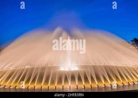 Deutschland, Niedersachsen, Hannover, Glockenbrunnen des Parterres des beleuchteten Herrenhauser Gartens am Abend, im Hintergrund Schloss Stockfoto