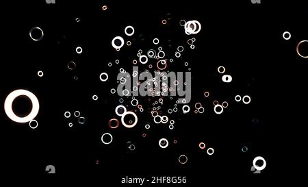 Abstrakte Animation von weißen und roten kleinen grünen Ringen, die auf dem schwarzen Hintergrund schweben. Kreises Rahmen fliegen weg in der Dunkelheit und verschwinden. Stockfoto