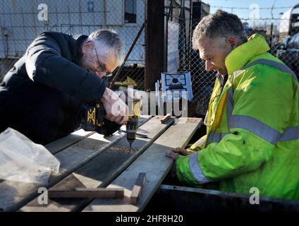 Zwei Männer, die zusammen arbeiten, bohren Holzstruktur Stockfoto