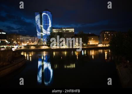 glasfront des UNIQA Turms in wien, beleuchtet mit verschiedenen Farben und Spezialeffekten bei Nacht, Wien Stockfoto