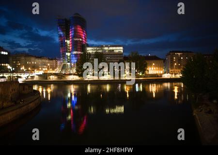 glasfront des UNIQA Turms in wien, beleuchtet mit verschiedenen Farben und Spezialeffekten bei Nacht, Wien Stockfoto