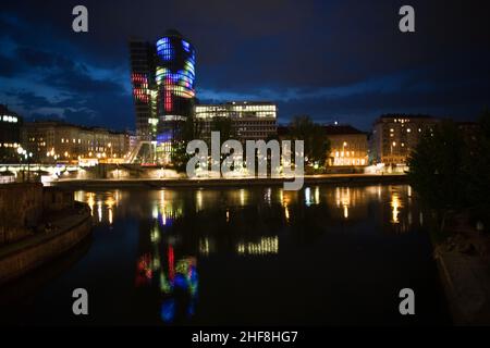 glasfront des UNIQA Turms in wien, beleuchtet mit verschiedenen Farben und Spezialeffekten bei Nacht, Wien Stockfoto