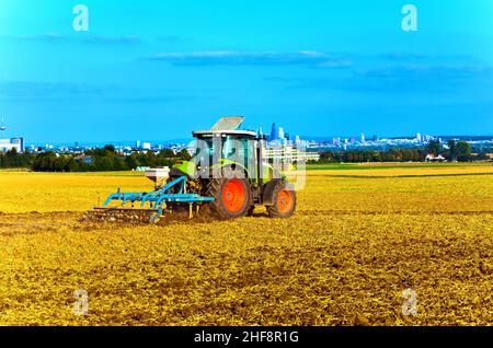 Kleine Landwirtschaft mit Traktor und Pflug im Feld Stockfoto